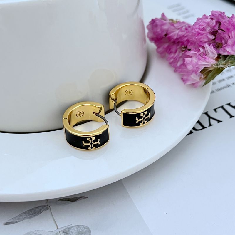 Clean, bright shot of a single huggie against a dark background, making the gold tone, CZ sparkle, and enamel color pop dramatically.