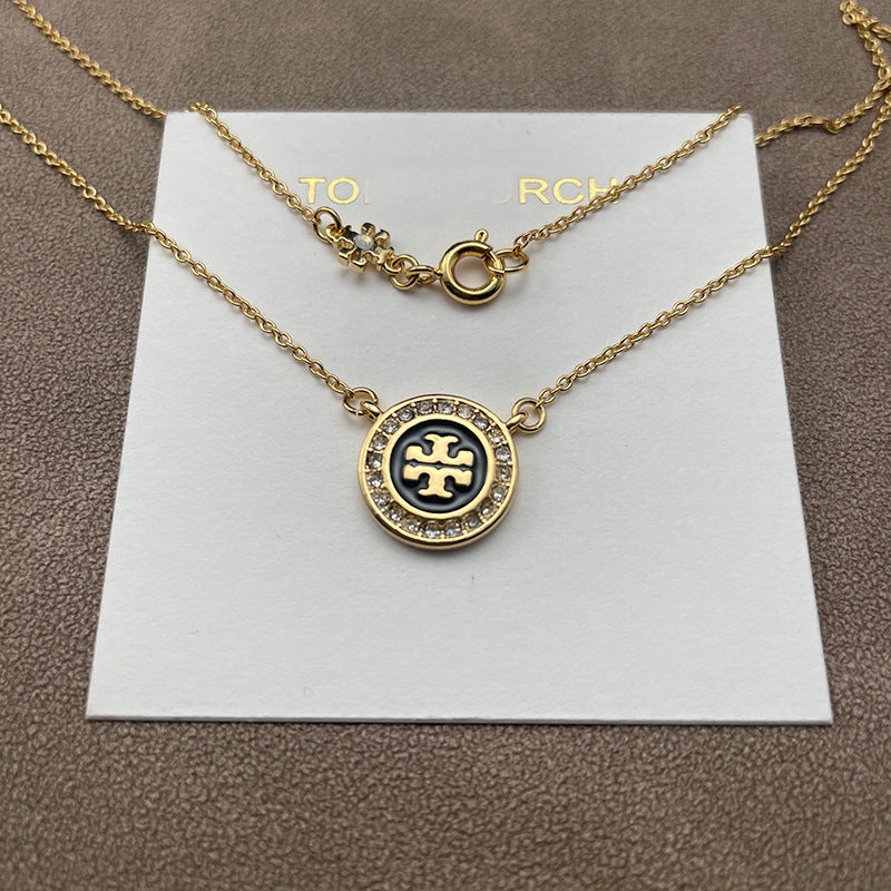 Extreme close-up of the Double T pendant, focusing on the precision of the pavé setting and the brilliance of each crystal.