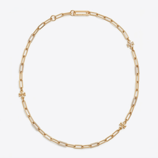 A gold chain necklace with alternating polished and textured links, arranged in a neat circle on a light gray background.