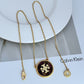 Gold necklace with a purple pendant on a white surface