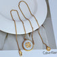 Gold necklace with a pendant on a white surface, Calvin Klein brand visible