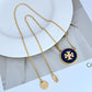Gold necklace with a blue pendant on a white surface