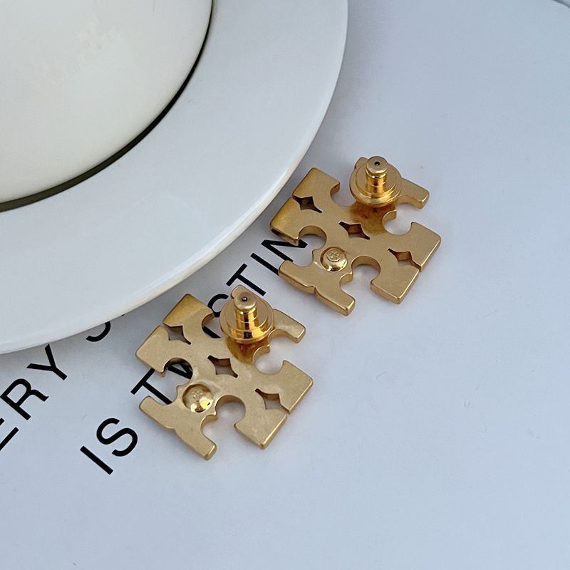 High-resolution shot of a single stud against a dark background, capturing the intense sparkle of the pave stones set within the iconic logo shape.
