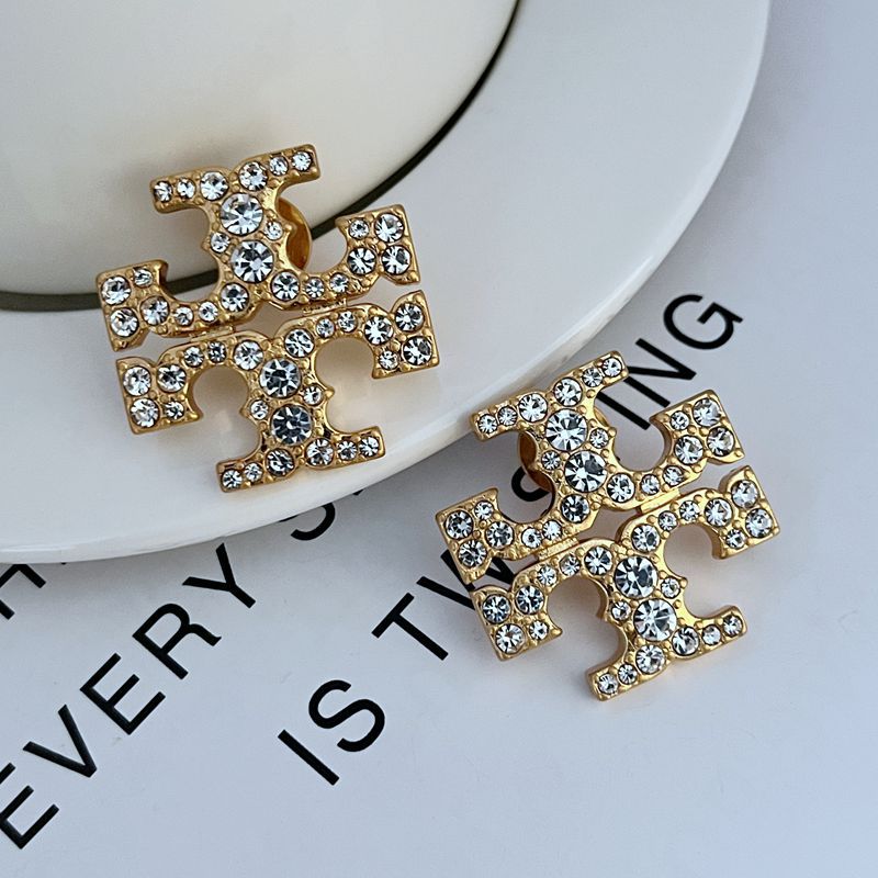 High-resolution shot of a single stud against a dark background, capturing the intense sparkle of the pave stones set within the iconic logo shape.