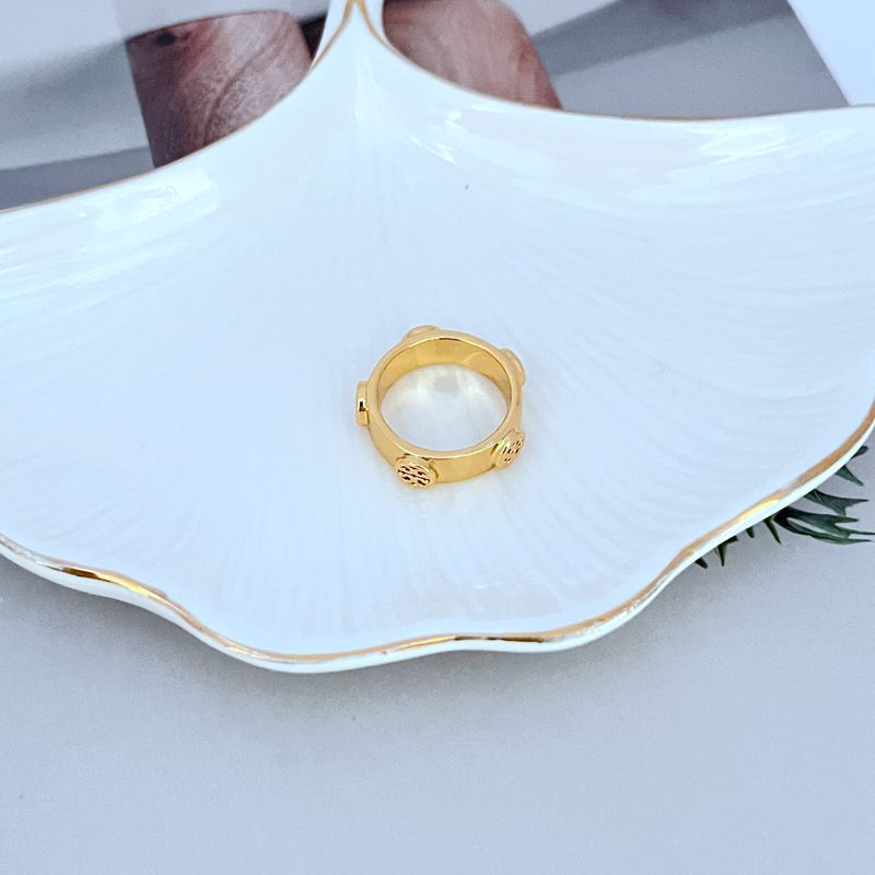 Clean, front-facing shot of the ring on a velvet pad or neutral background, highlighting the polished Double T logo.