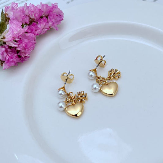 Both earrings displayed hanging against a clean background, clearly showing the Kira charm(s) and any layered elements.