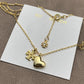 Close-up focused on the charm cluster, highlighting each element: crystal sparkle, heart shape, pearl luster, and engraved T logo.