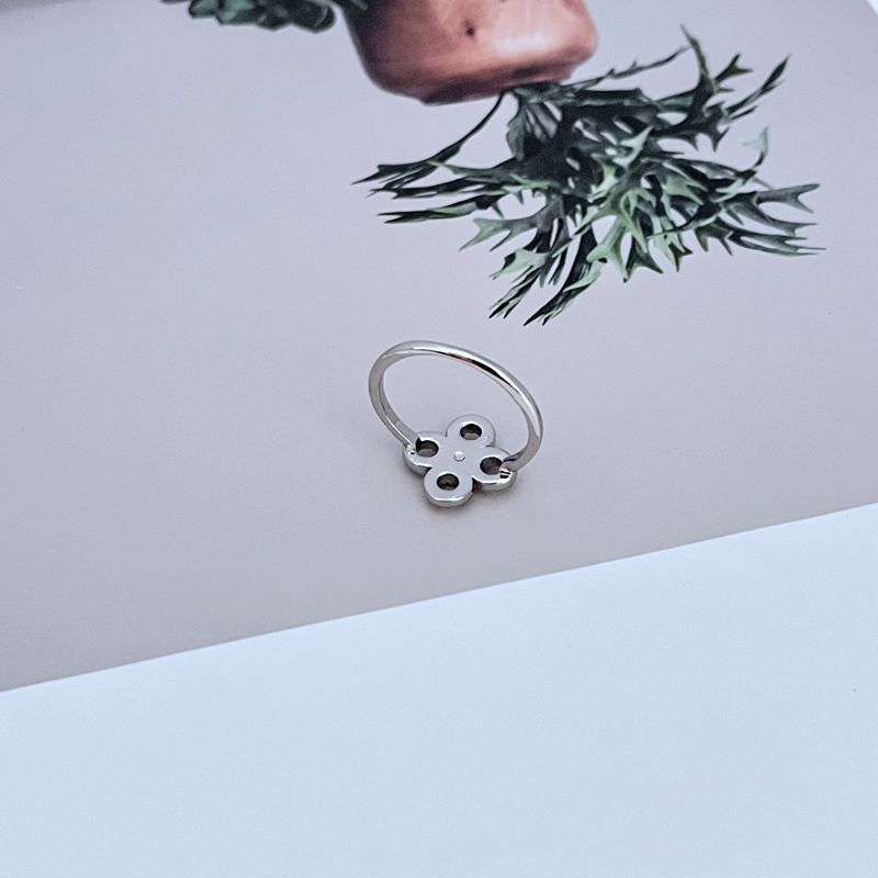 A woman with a joyful, fresh style, perhaps in a garden or sunny setting, wearing the ring as a charming, personal accent.