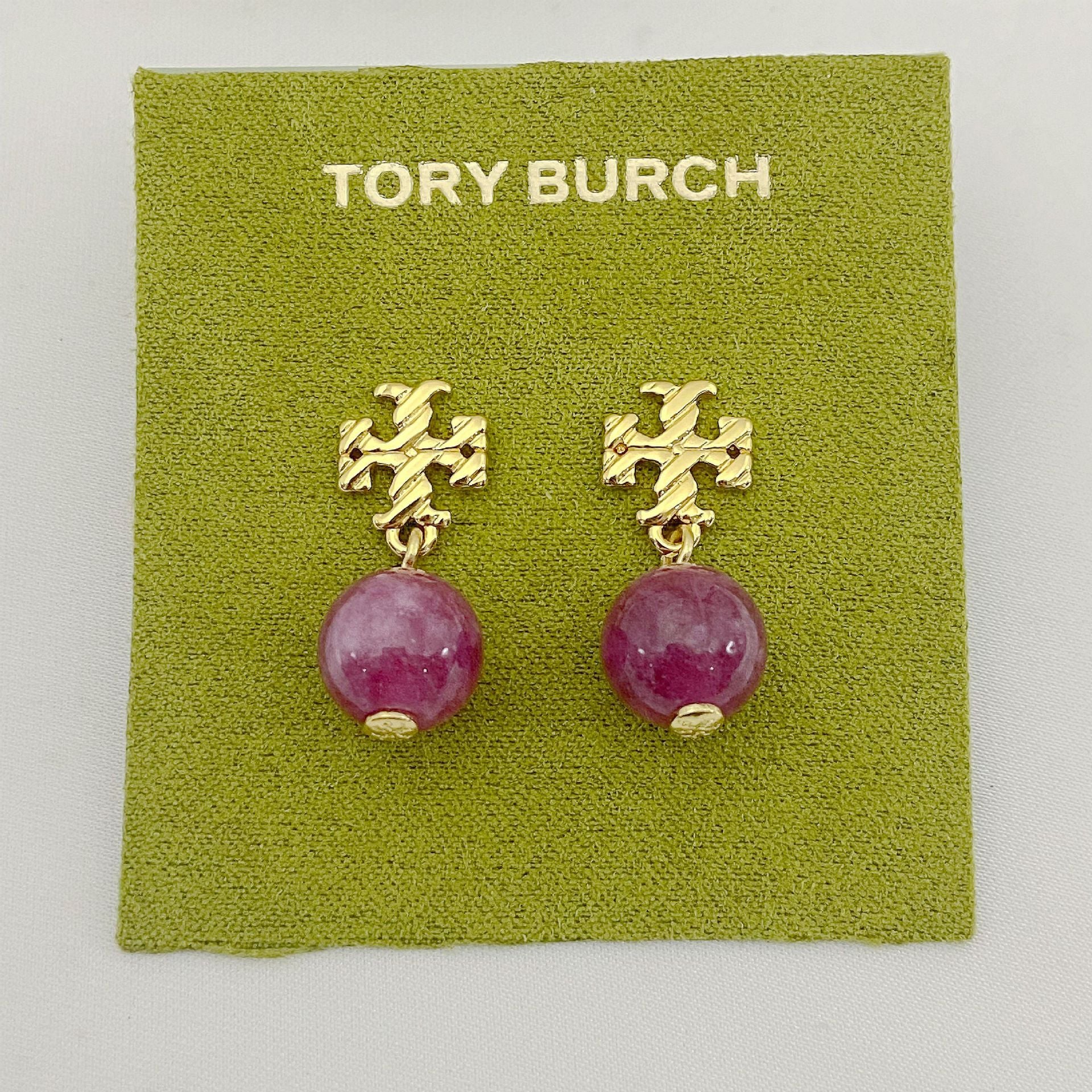 Tory Burch earrings with pink beads on a green card