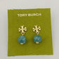 Gold earrings with turquoise beads on a Tory Burch branded green card.