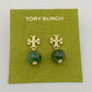 Gold earrings with green beads on a Tory Burch branded card.