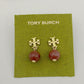 Tory Burch earrings with gold tops and red beads on a green card.