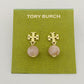 Gold earrings with pink beads on a Tory Burch branded card.