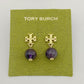 Gold earrings with purple beads on a Tory Burch branded card.