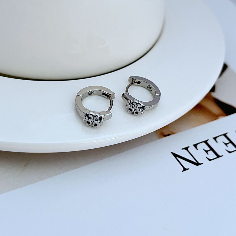 "Close-up macro shot focusing on the smooth, glossy enamel inlay and the polished gold edges of the huggie earring."