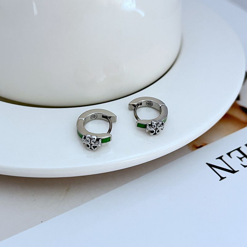 "Close-up macro shot focusing on the smooth, glossy enamel inlay and the polished gold edges of the huggie earring."