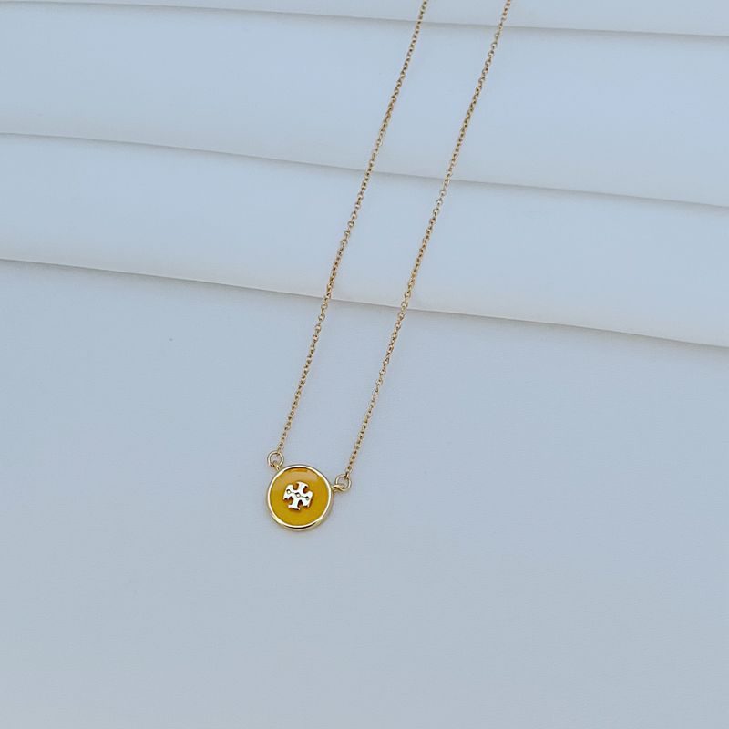 The necklace laid flat on a clean white or light gray background, making the enamel colors and gold-tone frame stand out vividly.