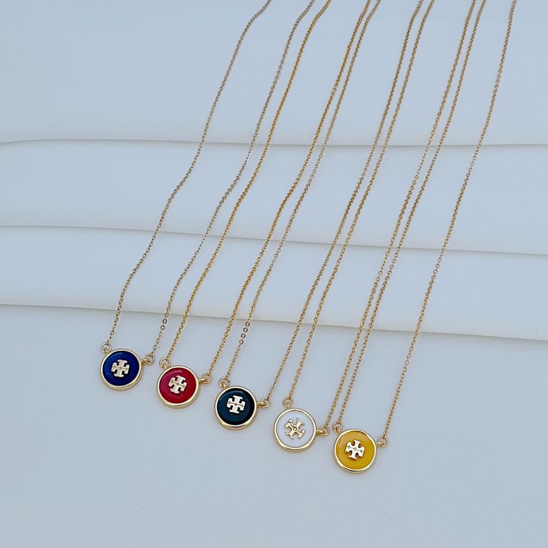 The necklace laid flat on a clean white or light gray background, making the enamel colors and gold-tone frame stand out vividly.
