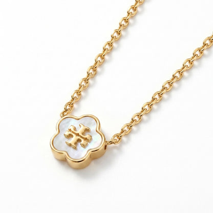 A gold chain necklace featuring a clover-shaped pendant with a white mother-of-pearl inlay and a gold monogram logo in the center, shown on a clean white background.