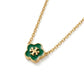 A gold chain necklace featuring a four-petal clover pendant with a glossy green enamel center and a gold interlocking T logo, shown on a clean white background.