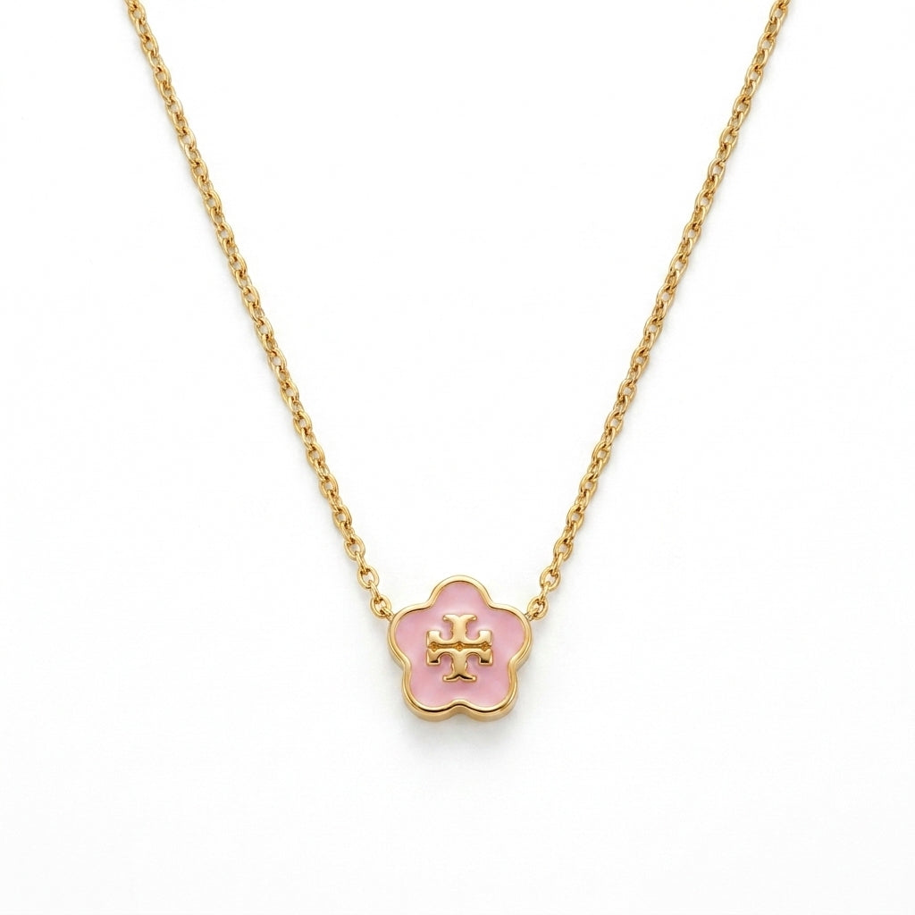 A gold-plated flower-shaped pendant necklace with a light pink enamel center and a gold cross in the middle, shown on a clean white background.
