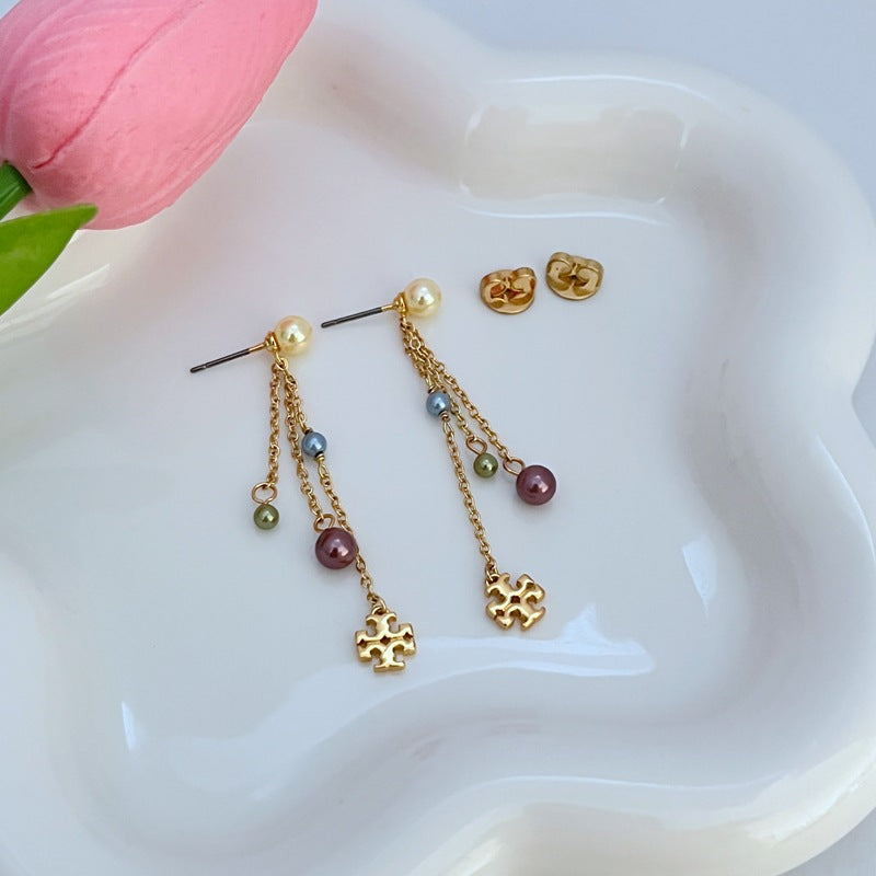 Macro view focusing on the precise Double T logo engraving on the bar and the flawless, lustrous surface of the imitation pearl.