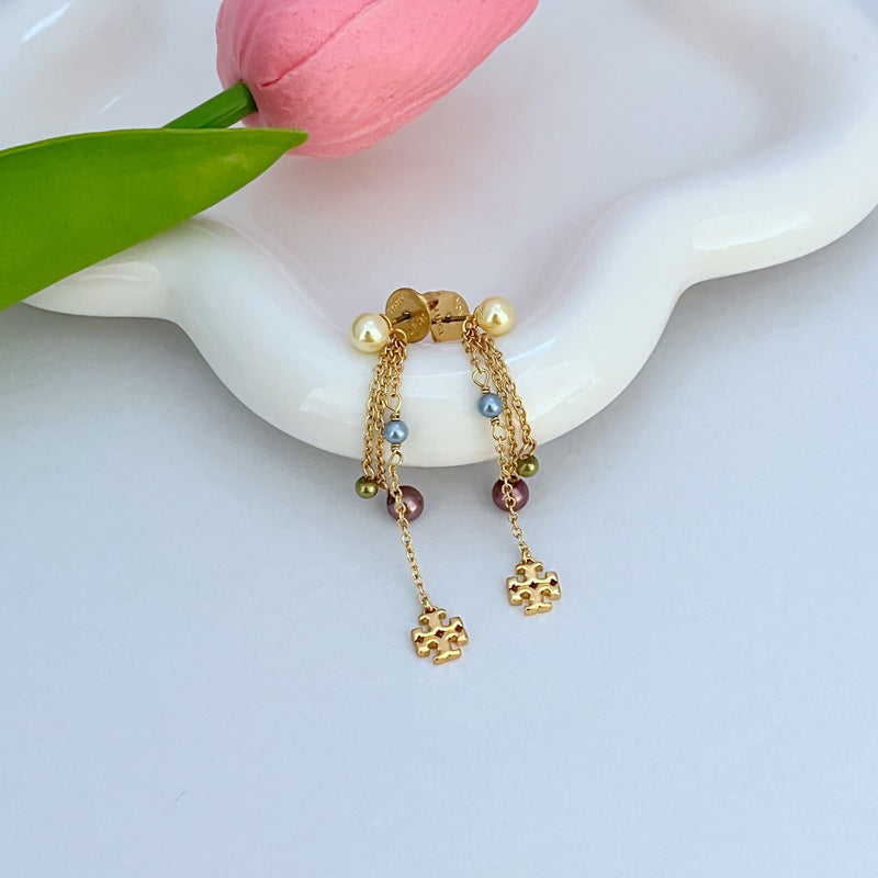 Macro view focusing on the precise Double T logo engraving on the bar and the flawless, lustrous surface of the imitation pearl.