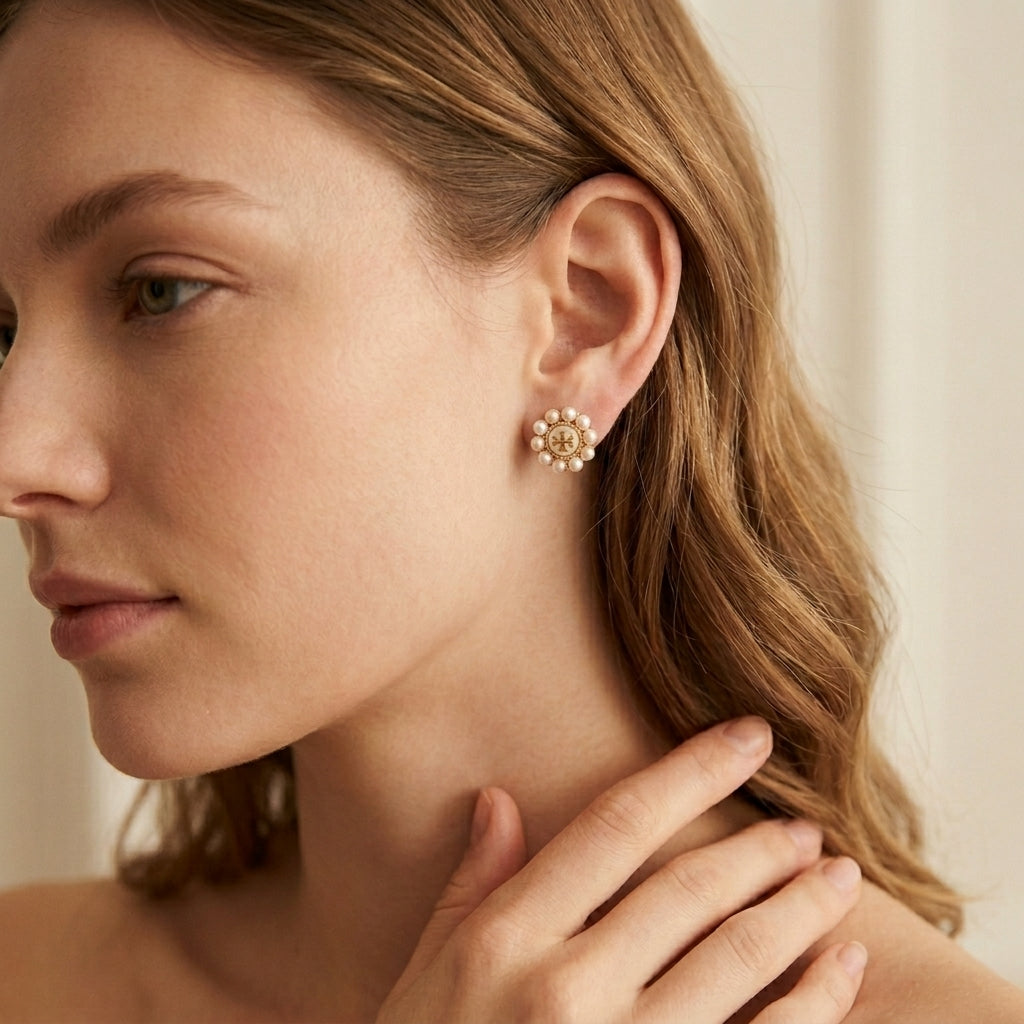 Close-up of a woman wearing gold earrings with a neutral background