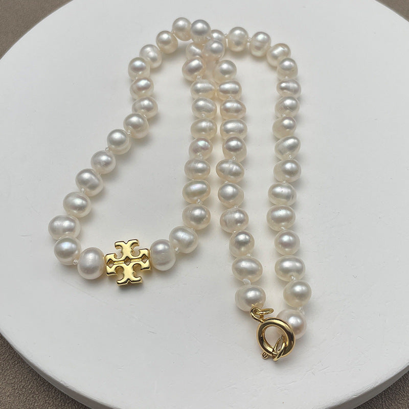 Close-up focused on the chevron frame cradling the pearl, showcasing the pearl’s surface sheen and the metal’s polished finish.
