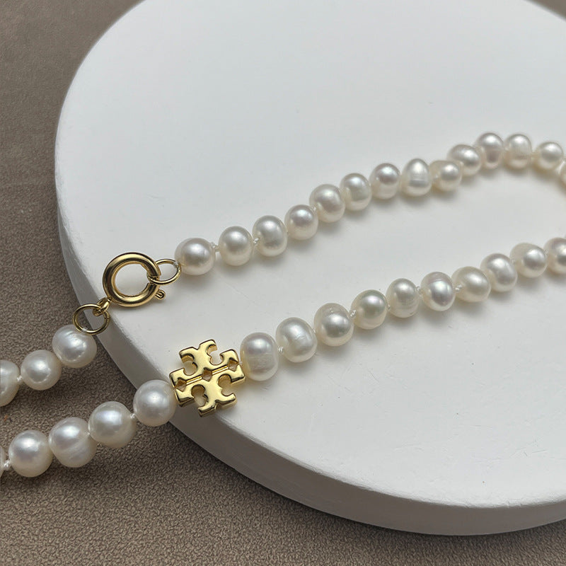 Close-up focused on the chevron frame cradling the pearl, showcasing the pearl’s surface sheen and the metal’s polished finish.