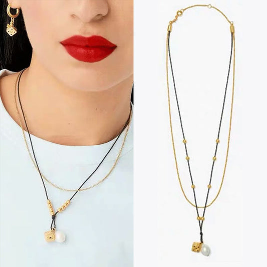 Necklace worn with a simple crewneck or blouse, capturing how the pendant rests at the collarbone for a polished, versatile look.