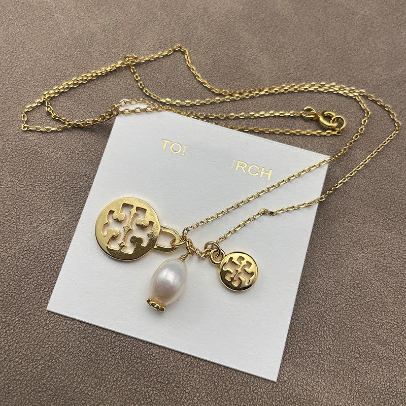 Necklace laid flat on a soft, neutral backdrop (light gray or cream), clearly showing both pendants spaced evenly along the chain.