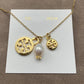 Necklace laid flat on a soft, neutral backdrop (light gray or cream), clearly showing both pendants spaced evenly along the chain.