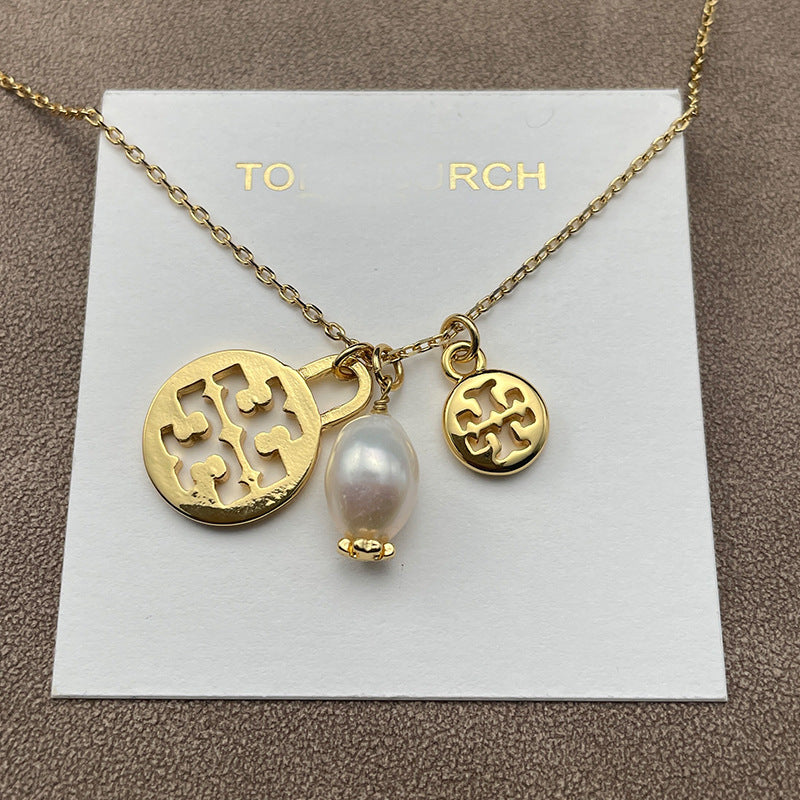 Necklace laid flat on a soft, neutral backdrop (light gray or cream), clearly showing both pendants spaced evenly along the chain.