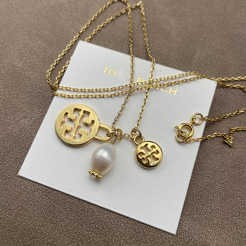 Necklace laid flat on a soft, neutral backdrop (light gray or cream), clearly showing both pendants spaced evenly along the chain.