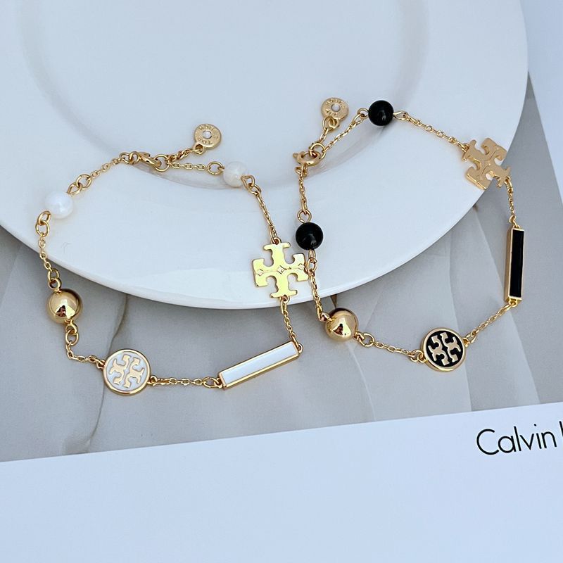 Close-up focusing on a cluster of chevron beads and a charm, showcasing their detailed texture and finish.