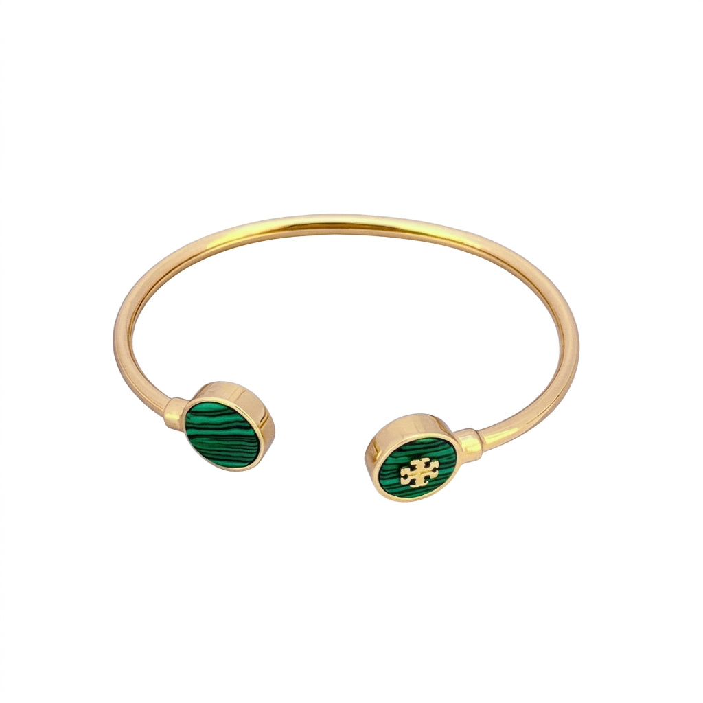 Gold-tone open cuff bangle bracelet with oval green malachite inlays on both ends, shown on a plain white background.
