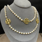 Necklace laid flat in a draped or straight line, clearly showing the repeating logo charms and the cross pendant at the center or end.