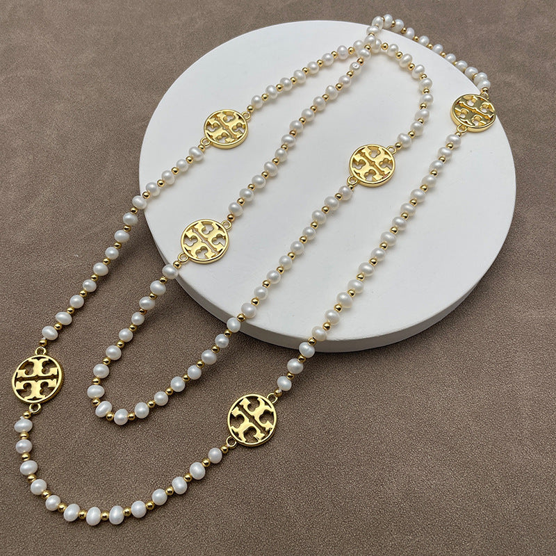 Necklace laid flat in a draped or straight line, clearly showing the repeating logo charms and the cross pendant at the center or end.