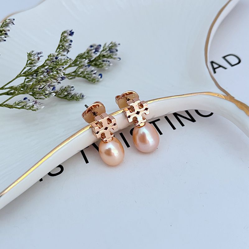 Clean, vertical shot of a single earring against a soft, neutral background, clearly showing the Double T logo above the pearl drop.