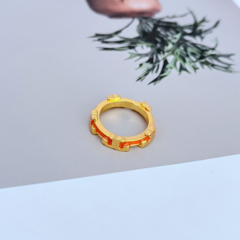 Clean, angled shot of the ring on a plain background, highlighting the sculpted serif 'T' shape and the vibrant enamel fill.