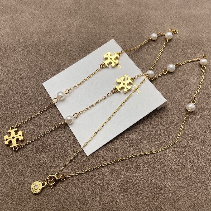 Close-up of the engraved crescent moon pendant and the adjacent pearls, highlighting texture and luminous finishes.