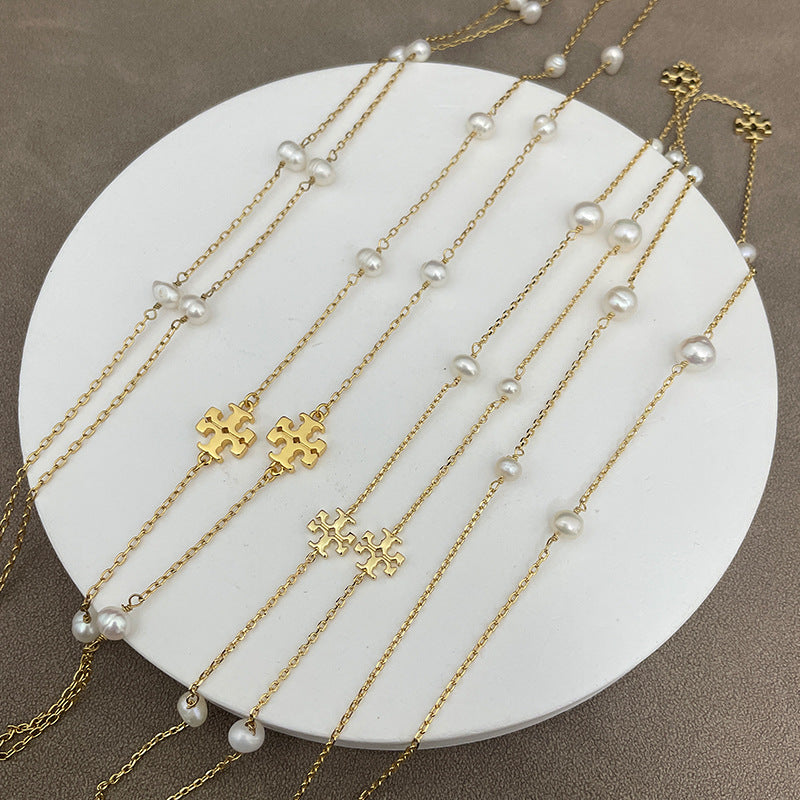 The necklace laid flat on a soft, neutral background (linen or light gray), clearly showing the multi-strand design, pearl placement, and moon pendant.