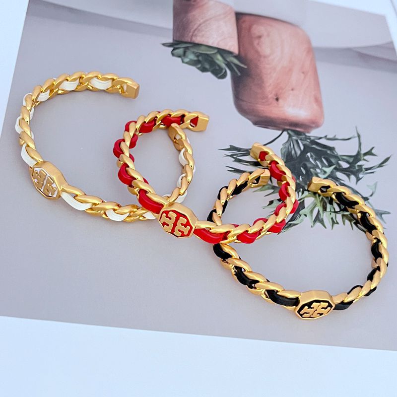 Close-up focusing on the intersection of leather and chain, and the engraved Double T logo.