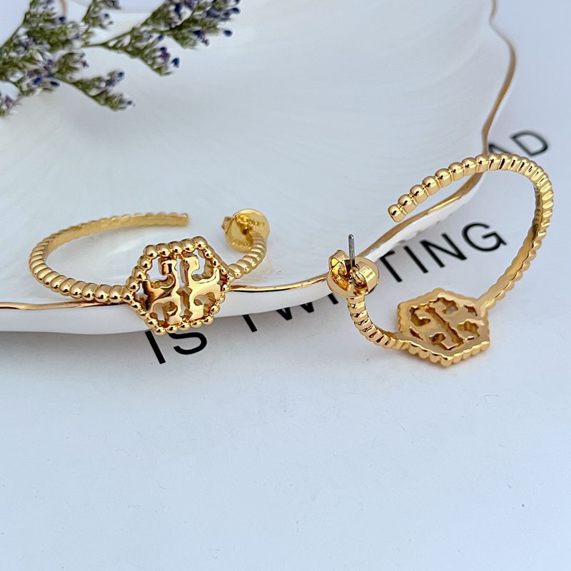 Both hoops displayed flat or slightly angled on a neutral background, highlighting the hexagonal shape, rolled edge, and milgrain beading.