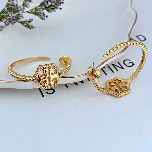 Both hoops displayed flat or slightly angled on a neutral background, highlighting the hexagonal shape, rolled edge, and milgrain beading.