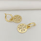 Gold hoop earrings with intricate designs on a light gray background