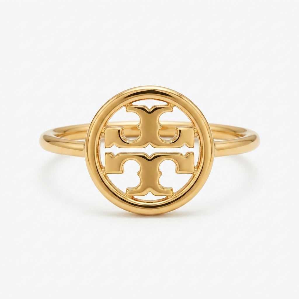A gold ring featuring a circular openwork design with the interlocking Tory Burch logo at the center, set against a clean white background.
