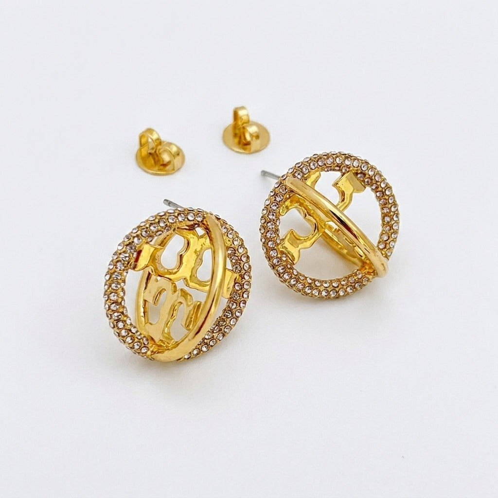 Gold hoop earrings with intricate designs on a white background