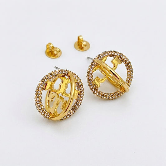 Gold hoop earrings with intricate designs on a white background